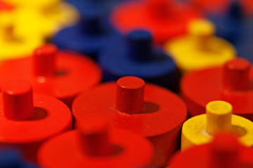 red, yellow and blue wooden play pieces in close-up