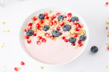 Smoothie bowl with yogurt, granola, blueberries, pomegranate seeds and shredded coconut. Healthy breakfast.