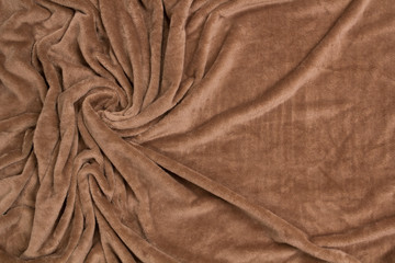 The blanket of furry fleece brown fabric. A background soft plush fleece material with a lot of relief folds