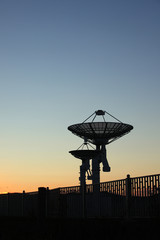 The silhouette of a radio telescope