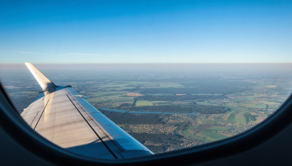 Suburb of a large European city through the porthole of an airplane