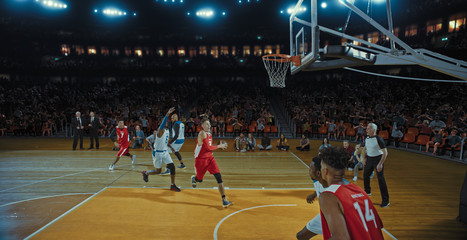 Basketball players on big professional arena during the game. Tense moment of the game. Celebration