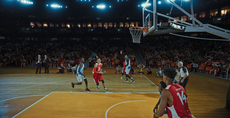 Basketball players on big professional arena during the game. Tense moment of the game. Celebration