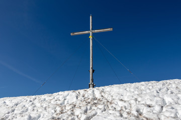 Fototapeta na wymiar Summit Cross of Jochberg, 1565 m in Winter. Located in Bavarian Prealps near Kochel am See, Upper Bavaria, Germany