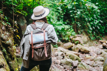 backside of Asian women with backpack standing on the forest