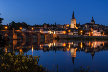 Fototapeta na wymiar La Charité sur Loire, a typical french village in Burgundy (FRANCE) reflecting on the river Loire at the blue hour.