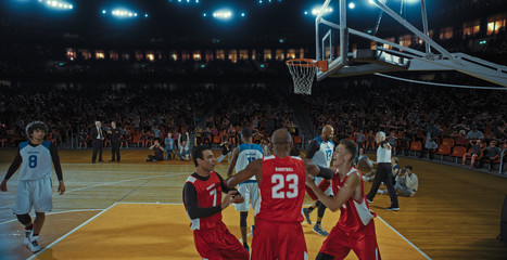 Basketball players on big professional arena during the game. Tense moment of the game. Celebration
