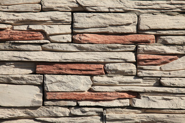 Decorative wall texture, background. Stone cladding in different colors grungy and matted stone bricks. The fragment of a new decorative stone laying. The design of multi-colored stylish exterior