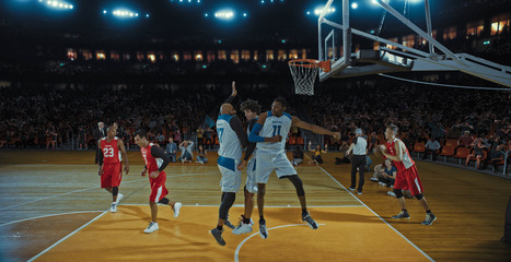 Basketball players on big professional arena during the game. Tense moment of the game. Celebration