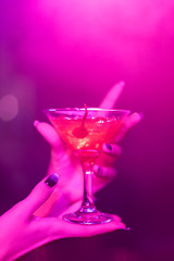 cocktail in the hand of a young girl in a nightclub