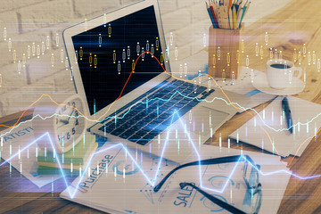 Double exposure of graph and financial info and work space with computer background. Concept of international online trading.