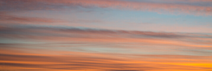 Naklejka na ściany i meble Fiery orange sunset. Beautiful clouds against the darkening sky