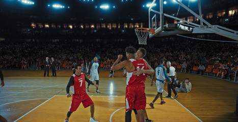 Basketball players on big professional arena during the game. Tense moment of the game. Celebration