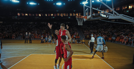 Basketball players on big professional arena during the game. Tense moment of the game. Celebration