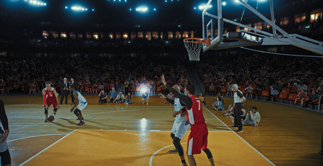 Basketball players on big professional arena during the game. Tense moment of the game. Celebration