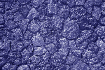 Wall made of old stones in blue tone.