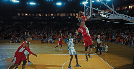 Basketball players on big professional arena during the game. Tense moment of the game. Celebration