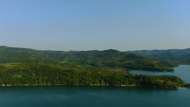 Lake Butoniga water dam in Croatia surrounded by mountains, Aerial drone left pan reveal shot