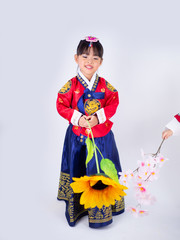 Asian little girl wearing a Korean Traditional Hanbok dress in white background[The pattern on the fabric is Fu Lu Shou refers to the three Chinese deities]