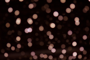 Golden abstract yellow, orange bokeh lights isolated on black background with copy space. Holiday and Christmas season concept, graphic resources, greeting card. wallpaper. Multi-colored lights.