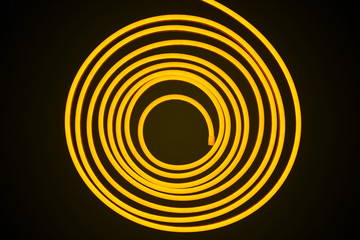 Flexible yellow led tape neon flex in roll on black background.