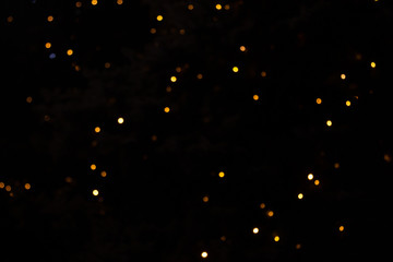 Golden abstract yellow, orange bokeh lights isolated on black background with copy space. Holiday and Christmas season concept, graphic resources, greeting card. wallpaper. Multi-colored lights.