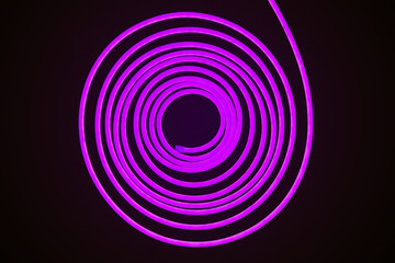 Flexible purple led tape neon flex in roll on black background.