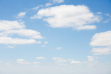 Blue sky background with white fluffy clouds in the fresh sunny day.
