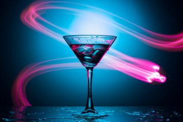 Martini glass with drink and ice, with a spectacular illumination of the background.