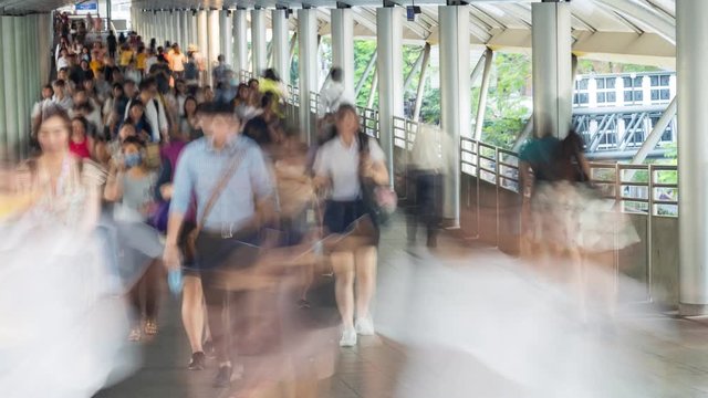Blurred motion of business people walking at  skywalk nearly  office building in the rush hour at monday morning.