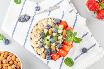 Smoothie bowl with blueberries, banana, strawberries, nuts, kiwi, quinoa, chia and mint. Concept of healthy lifestyle and eating. Healthy breakfast. Top view.