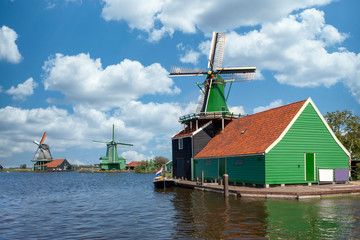 Fototapeta na wymiar Dutch green sawmill at the edge of river facing the wind and reading for servicing