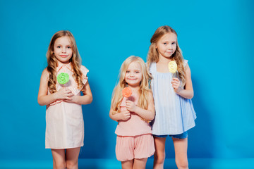 three little girls girlfriend eaten sweet candy lollipop on a stick