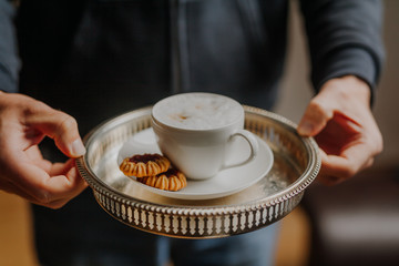 Man holding tray with cup of coffee