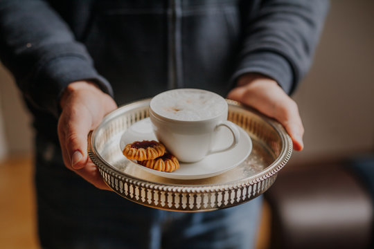 Man holding tray with cup of coffee
