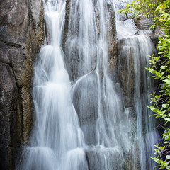 Closeup of a small waterfall in San Francisco, California, USA. Abstract relaxing water background wallpaper.  Long exposure square layout photo.