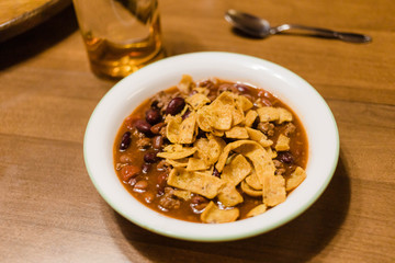 bowl of homemade chili with corn chips on the table