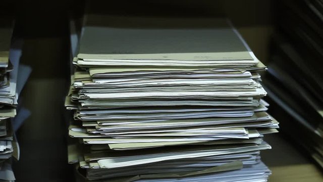 Stacks of old documents in the old archive. Brown, old data files.