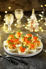 Stuffed eggs with salmon caviar. Christmas background.