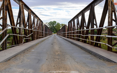 Fototapeta na wymiar Metal Old Bridge and road