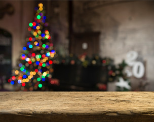 Empty table in front of christmas tree with decorations background. For product display montage.