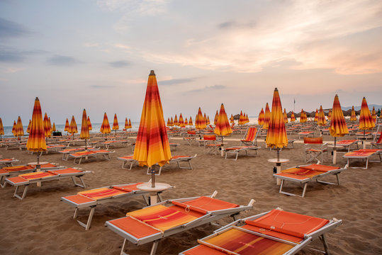 Orange Deckchair And Beach Umbrellas In An Empty Beach