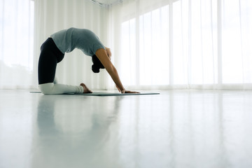 Asian woman practicing yoga in the white room, stretching in Ustrasana exercise, Camel pose, working out, ,Full length Concept of healing body and spirit,copy space
