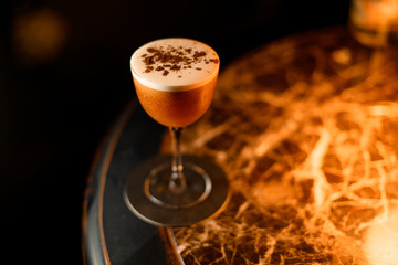 Brown alcoholic drink sprinkling on it with spices in the bar