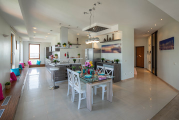 Interior of kitchen in modern studio apartment. Kitchen set and laid table. Luxury interior.