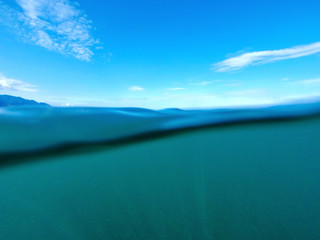 Seascape. Cloudy blue sky over the blue surface of the sea on a sunny day.