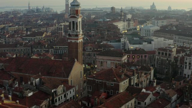 Aerial, tilt up, drone shot, close to the Chiesa Cattolica Parrocchiale dei Santi Apostoli, overlooking the cityscape of Venetsia, on a sunny evening, in Venice, Italy