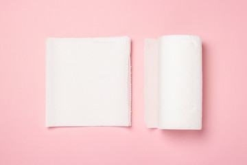 Roll of paper towels and few pieces towels on a pink background. Concept is 100 natural product,...