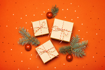 Christmas composition with gifts, branches and holiday elements on the orange background. Flat lay. Merry Christmas, New Year, winter concept.