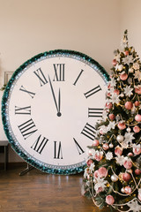 Christmas decor, large clock on which midnight and Christmas tree